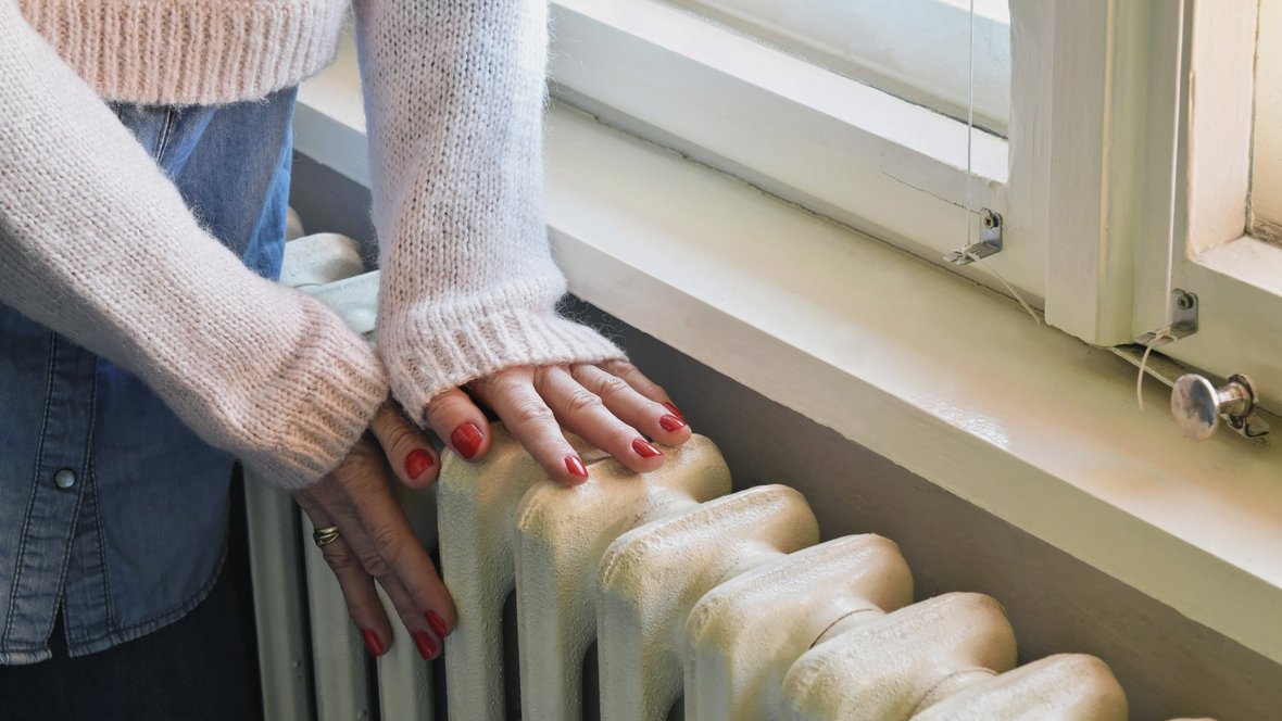 Kvinde luner hænderne på radiator