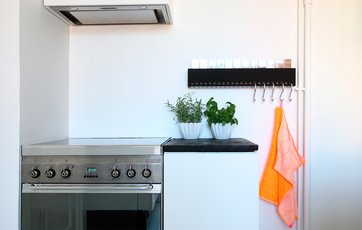 Køkkenet er hvidt med mintgrønt gulv, så de neonorgange viskestykker lyser rigtigt op. Foto: Jan Ove Kristensen