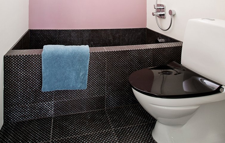 Fliseinspiration10 Badekar og gulv i sorte lavasten. Lyserød væg malet bag badekarret.