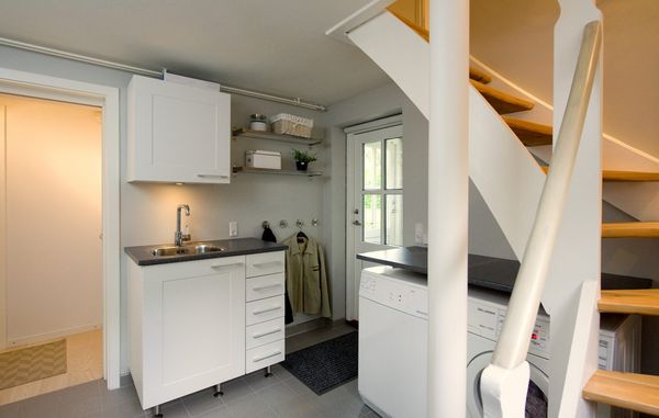 I dette bryggers er der både fundet plads til en vask lige ved indgangen, mens vaskemaskine og tørretumbler er gemt under trappen, der fører op til husets 1. sal. Foto: Torben Klint