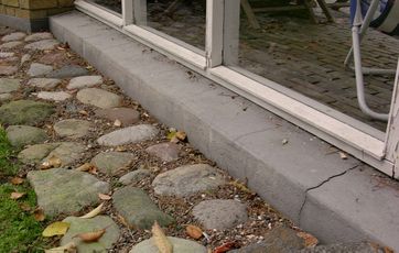 Revne i soklen under en terrassedør.