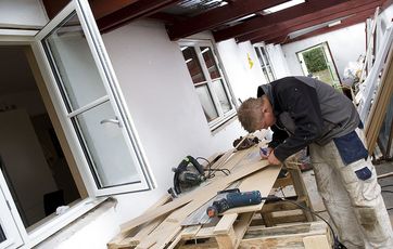 tømrer der arbejder foran hus