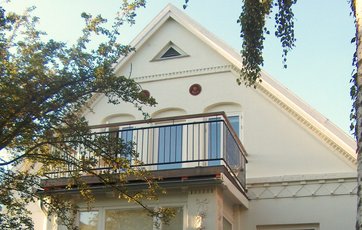 Her er altanen lavet oven på husets karnap. Det er en enkel og smuk altan, der passer til den ældre bolig.