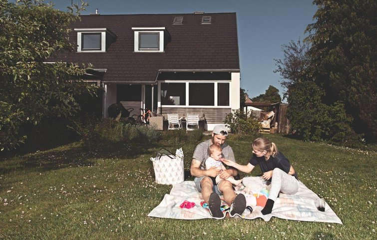 Familien sidder og leger i haven
