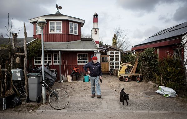 Gert Iversen går tur med hunden foran sit hus.