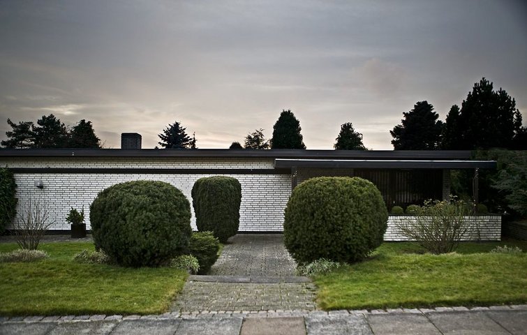 Hvid modernistisk villa med fladt tag set fra gaden