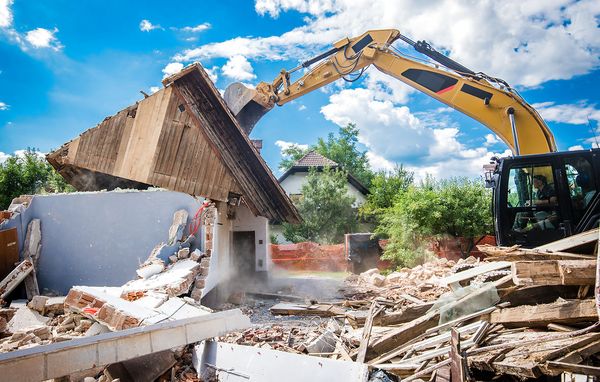 Nedrivning af faldefærdigt hus Stor maskine river tomt hus ned