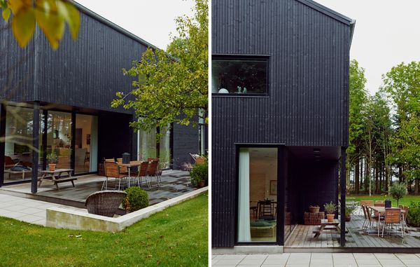 sort træhus med terrasse set fra have