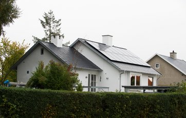 Taghældningen er 34 grader, så Allan blev nødt til at bruge sikkerhedsline og stillads, da har installerede solcellerne. Foto: Torben Klint