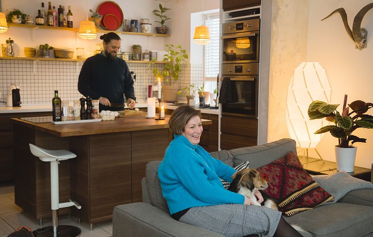 Jack Christensen laver mad i køkkenet, mens Diana Brandt Larsen slapper af med hunden i sofaen