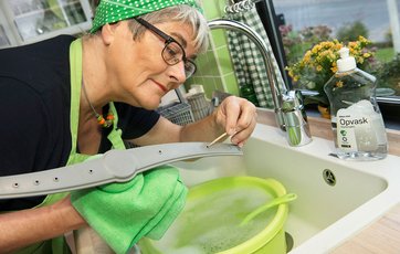 Fru Grøn renser opvaskemaskinens spulearm