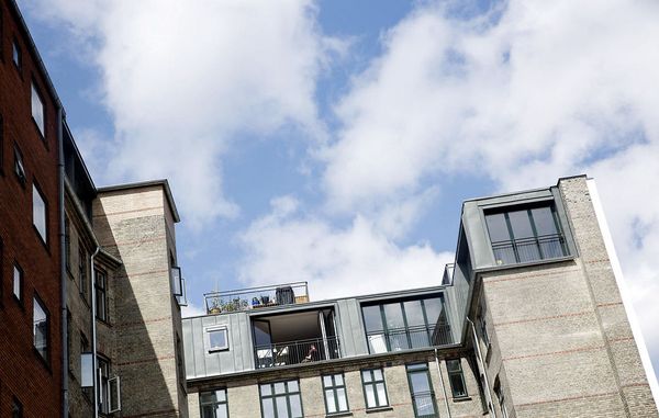 lejlighedskompleks med himmel og skyer i baggrunden