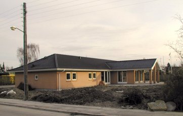 Parcelhus i mursten med helvalmet
tag.