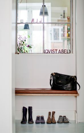 Reol og siddeplads med sko under og indvendigt vindue, der giver lys