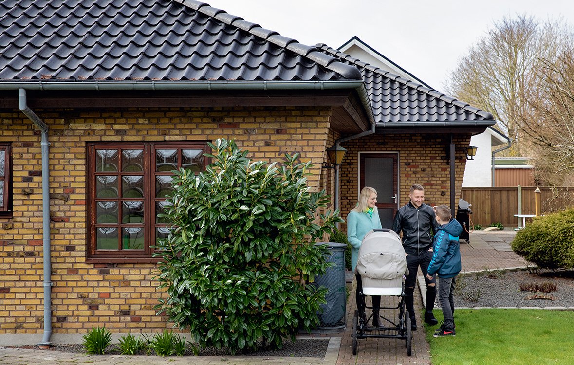 Veronika og Daniel med barnevogn og Veronikas søn foran deres hus i Lem