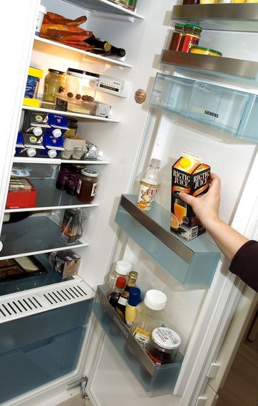 Hånd tager juice ud af køleskab