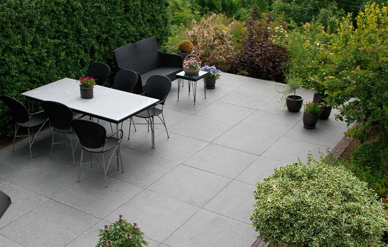 Befæstelsesgrad Terrasse med fliser og grønt omkring.