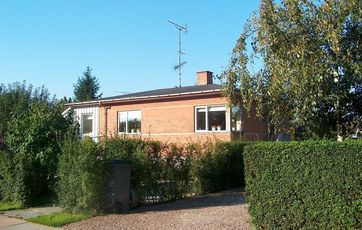 Bungalow i røde mursten med sort tag