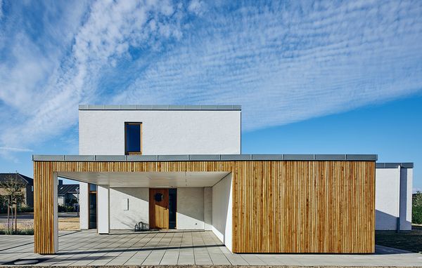 Moderne funkisvilla med carport i egetræ foran