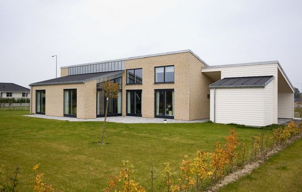 Morderne lavenergihus i gule teglsten med store vinduespartier.