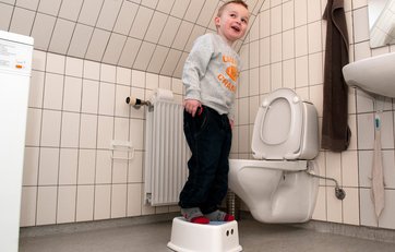 Dreng står op og skal til at tisse ned i toilettet