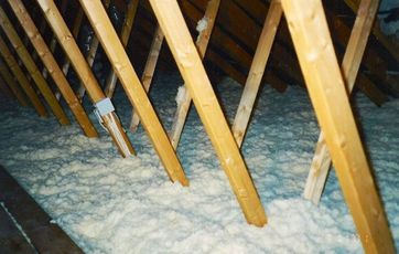 Efterisolering af loft med træfiber - til venstre ses en antydning af gangbroen.