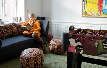 Mette læser i tv- og legestuen.