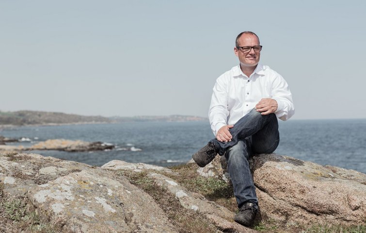 Rune Holm sidder på klipper ved vandet på Bornholm