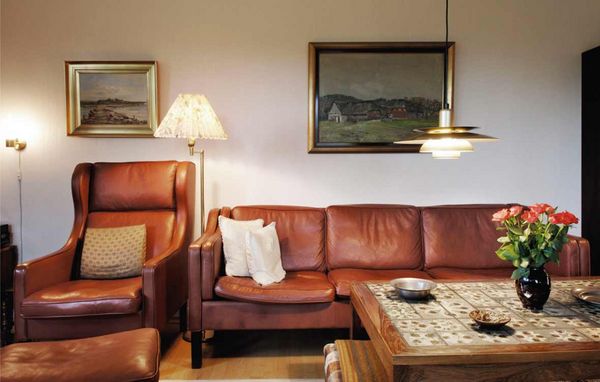 ALT-TEKST: Lædersofa og læderstol i stue ALT-TEKST: Lædersofa og læderstol i stue