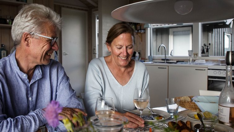 Mand og kvinde spiser mad og snakker sammen