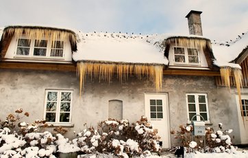 Du kan fjerne farlige istapper ved at slå dem i stykker med en kost.
