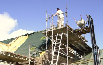 Murer arbejder på et stillads i 1. sals højde Murer arbejder på et stillads i 1. sals højde