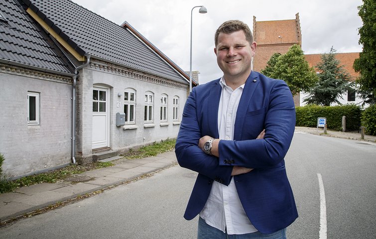 Jeppe Christensen Jeppe Christensen foran sit hus i Lumby med kirken i baggrunden.