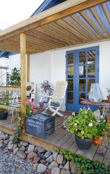 En overdækket træterrasse, der fungerer som shelter til sommerovernatninger.