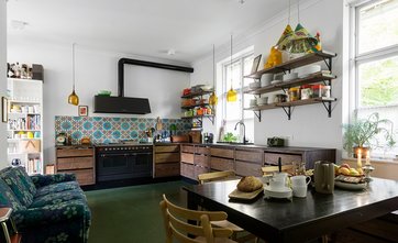 køkken med sortbejdset eg, farverige fliser og grøn linoleum