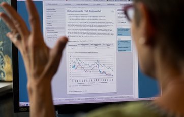 Kvinde er frustreret foran en computerskærm Kvinde er frustreret over økonomisk valg