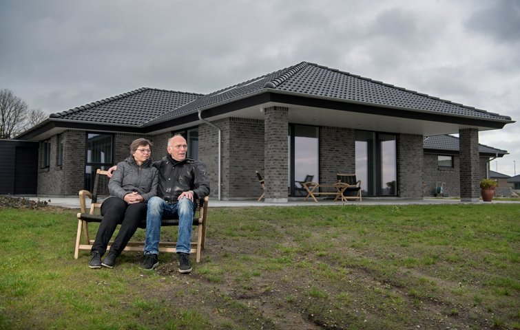 Henning og Metha sidder på bænk foran deres hus