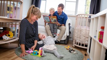Familien med to voksne, Oskar på 4 år og Vilja på 1 år, på børneværelset.