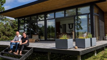 Peter Bigum og Lone Palshøj foran deres sommerhus, som de selv har bygget og indrettet