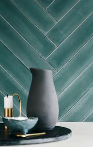 Cementflise3 Grøn cementflise på væggen bag køkkenbordet, hvor der står en kande og en lysestage.