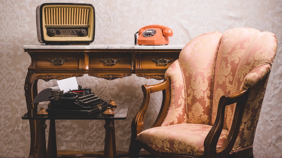 gammel telefon, radio og lænestol i bolig