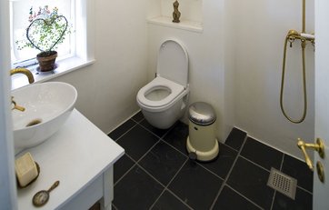 Badeværelse med toilet, håndvask og bruser