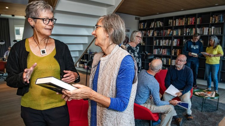 Mennesker taler sammen i bibliotek