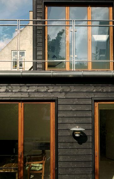 Smuk facade med sort træbeklædning.