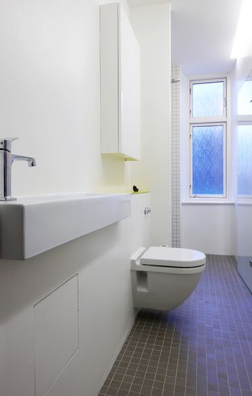 Væghængt toilet og en smal håndvask