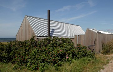 Sådan ser huset ud udefra: Et beskedent træhus ved vejen.