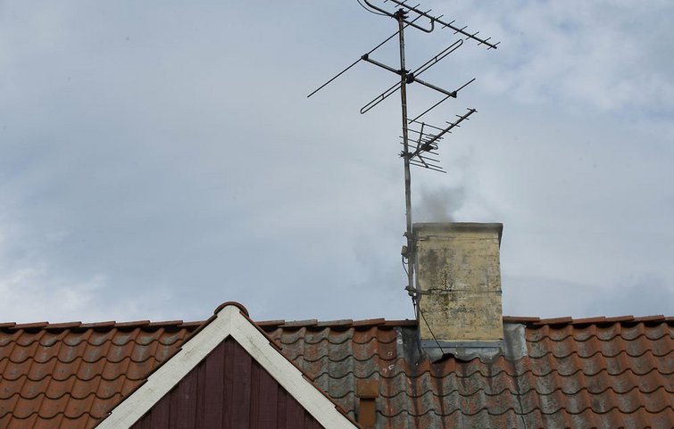 Røg fra skorsten Røg fra brændeovn kommer op gennem skorsten.