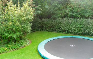 Trampolin gravet ned i græsplæne