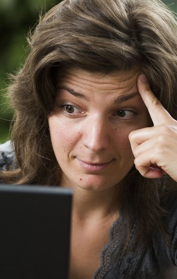 Overrasket kvinde kigger på computerskærm