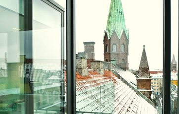 Fra de store vinduer er der udsigt over Københavns smukke bygninger.